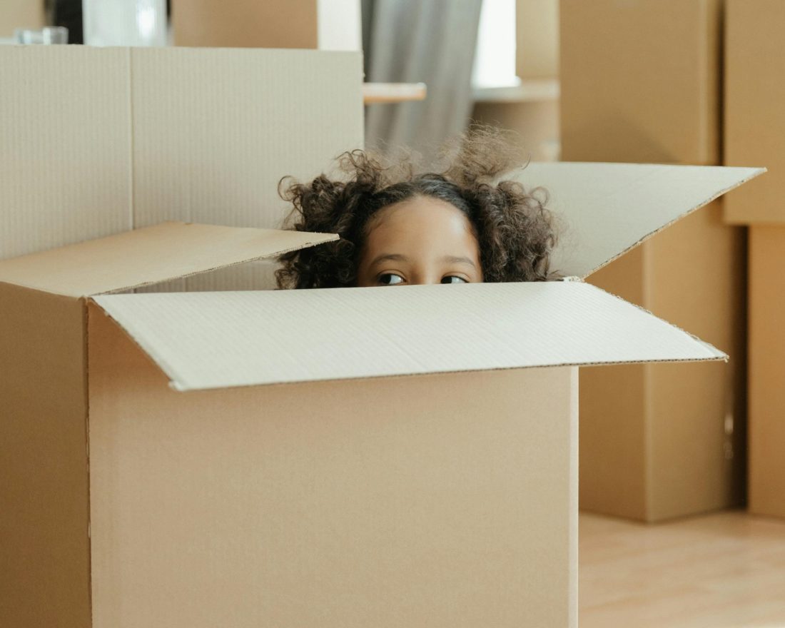 young-girl-peaking-out-of-cardboard-packaging